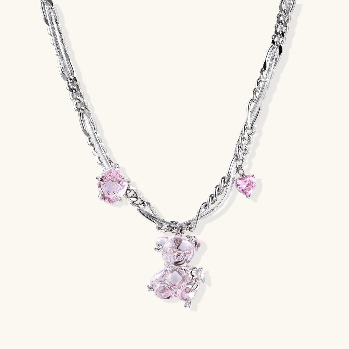 Adjustable gold-plated brass chain necklace with pink zirconia crystals and mixed link patterns on white background.