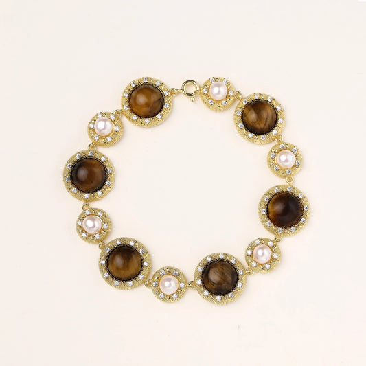 Ornate gold-plated bracelet with alternating brown tiger's eye stones and white freshwater pearls in crystal-accented settings