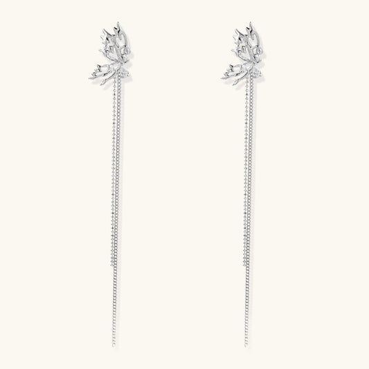 Long gold-plated earrings with star motifs and delicate chain tassels cascading down, featuring zirconia accents.