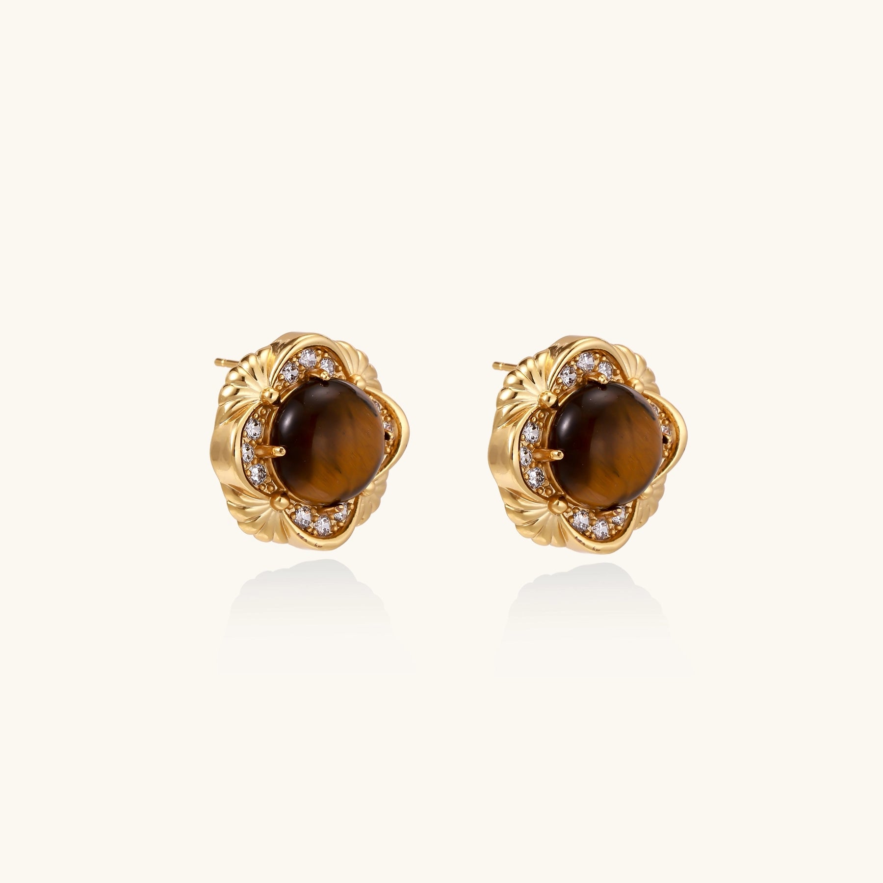 Ornate gold-plated brass stud earrings featuring round tiger's eye stones surrounded by sparkling zirconia in floral design