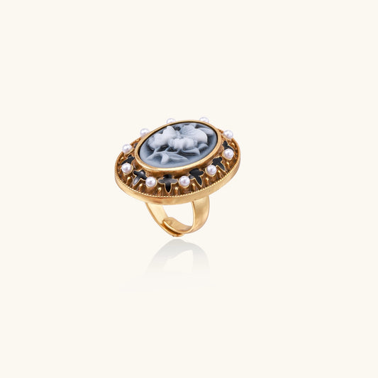 Oval cameo ring with blue-grey floral design surrounded by white shell pearls in gold-plated brass setting