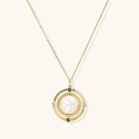 Gold-plated pendant necklace with circular orbital design, iridescent mother-of-pearl center and green zirconia accents