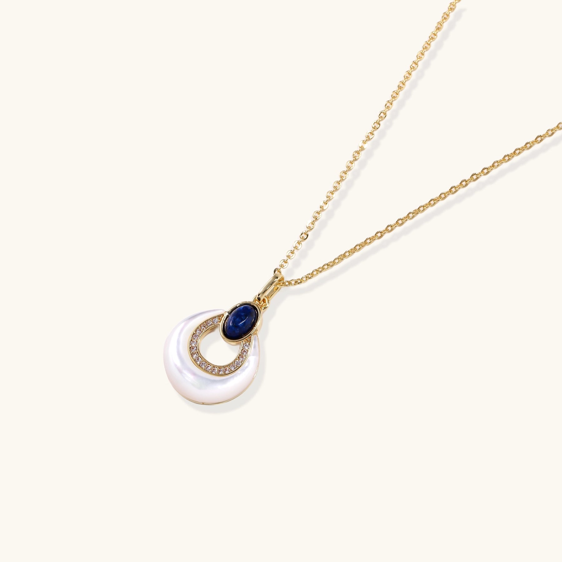 Layered pendant necklace with deep blue lapis lazuli stone, crystals, and white mother of pearl on 18k gold plated chain