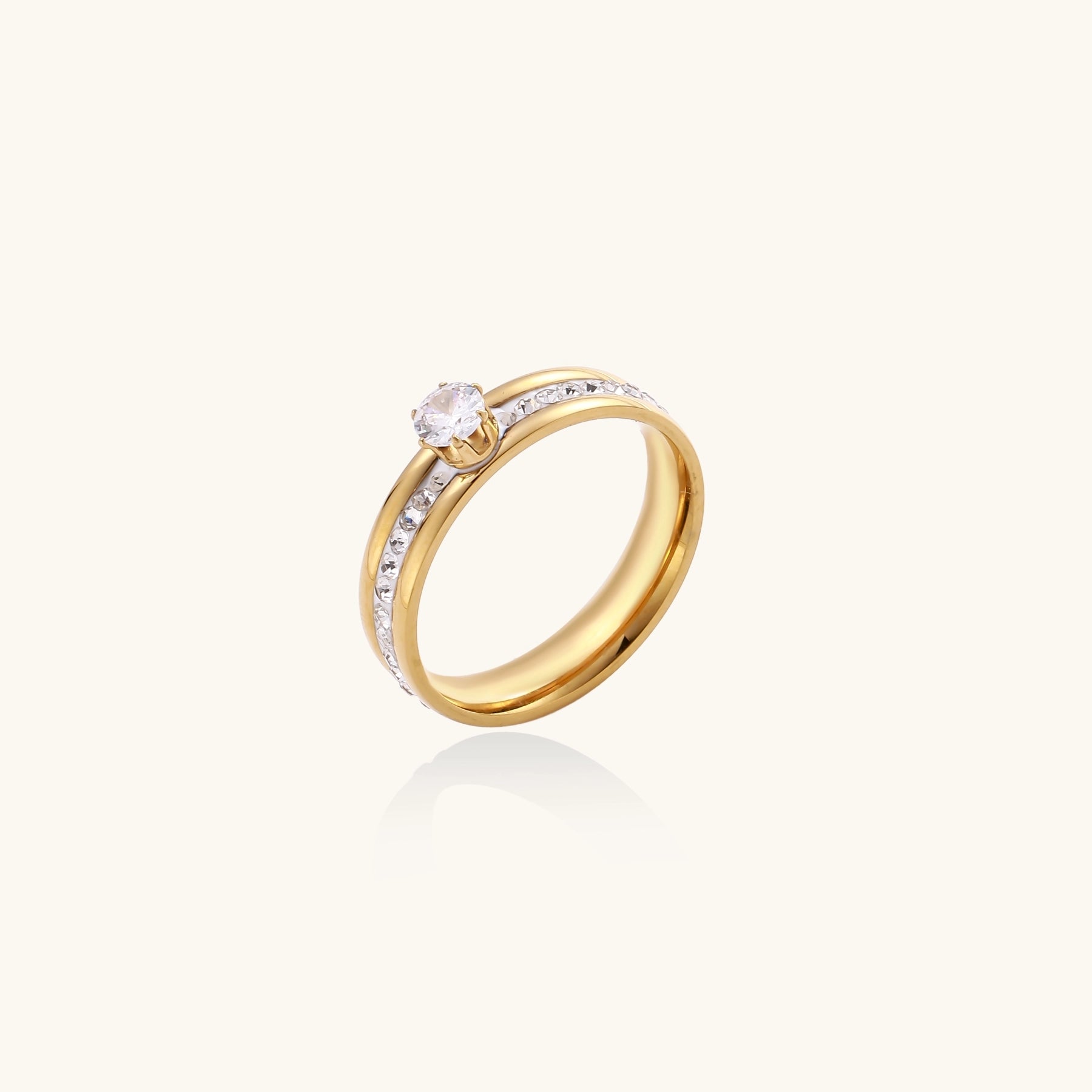 14K gold plated ring with center rhinestone and accent stones along the band on white background.